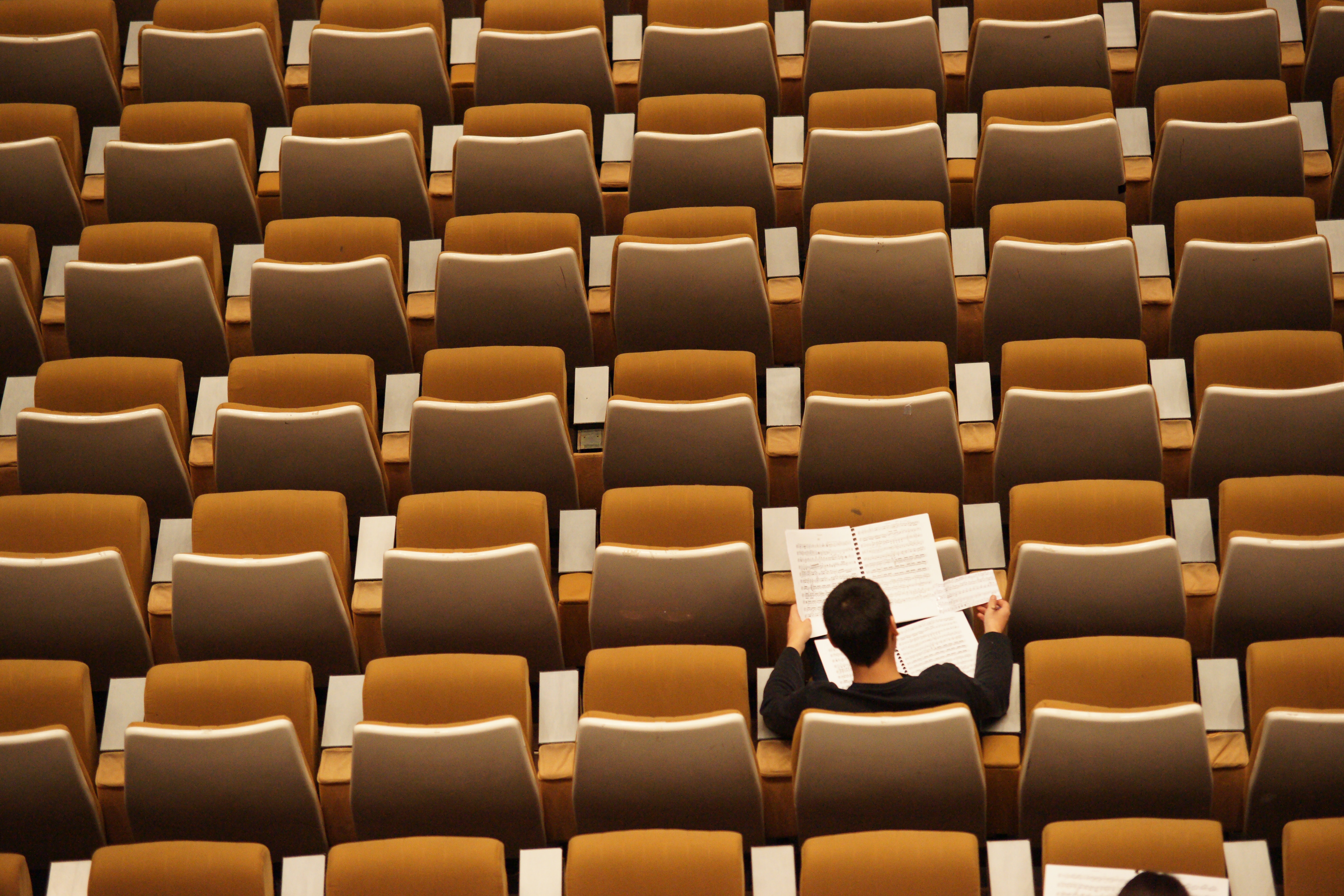 photo os a man in an auditorium reading a paper